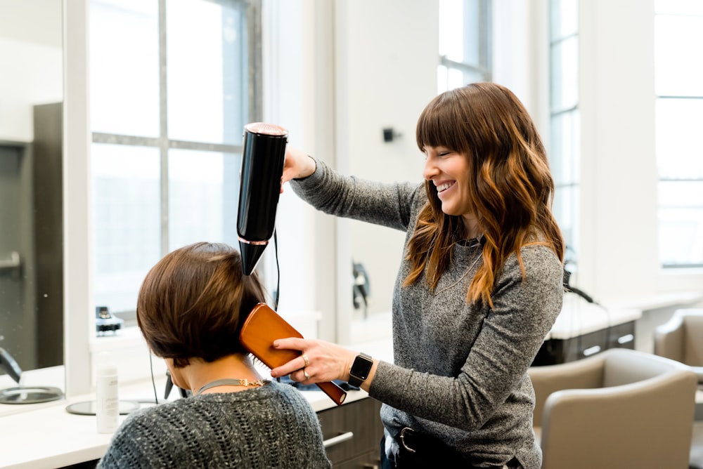 Coiffeuse réalisant un brushing dans le salon